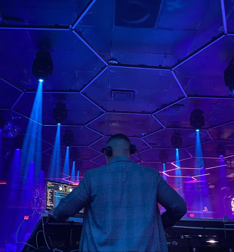 DJ Bodega behind the booth under blue lights