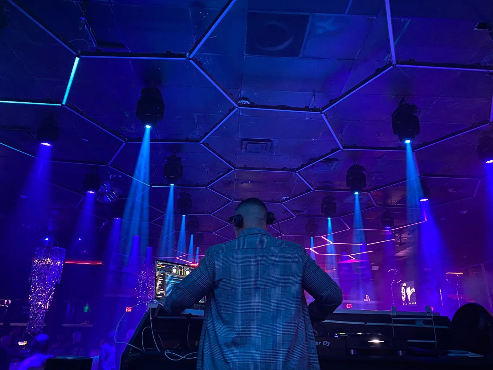 DJ at a club with blue hexagon lighting
