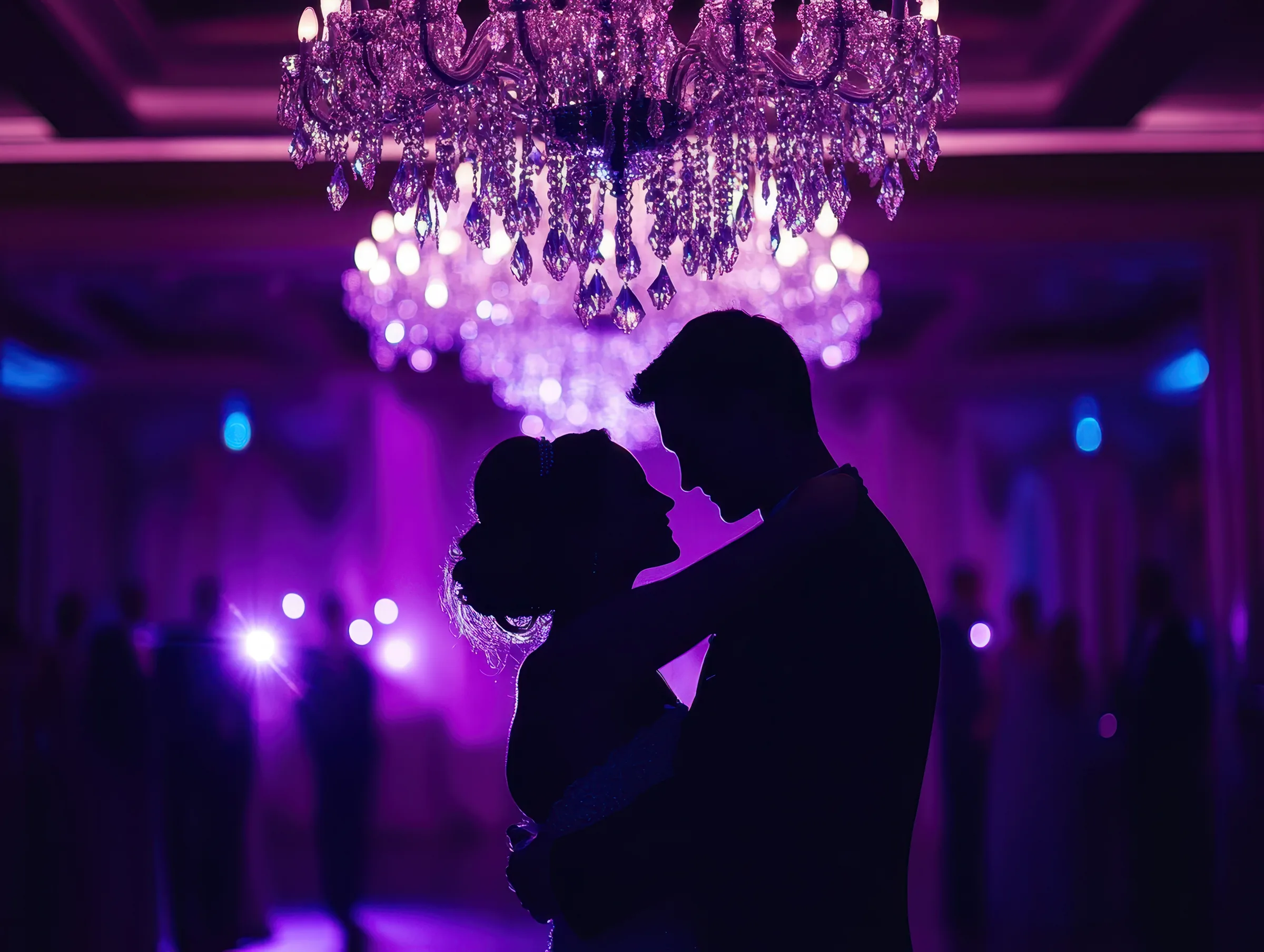 Couple dancing under a chandelier at a wedding reception